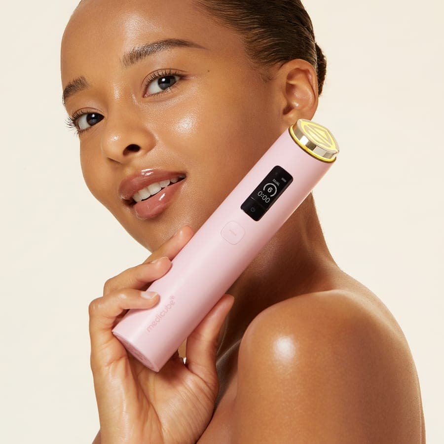 Modelo com o aparelho Booster Pro da Medicube